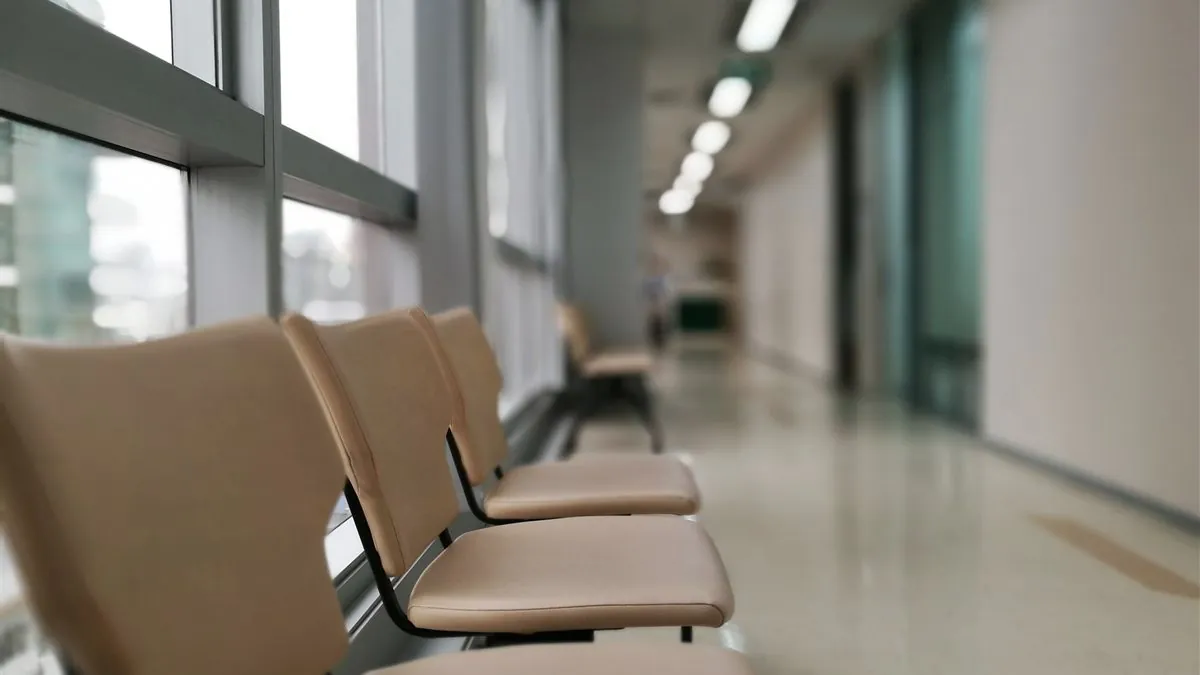 Empty seats along a hospital corridor, daylight coming through the windows